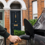 EV being plugged in by a man in domestic settting
