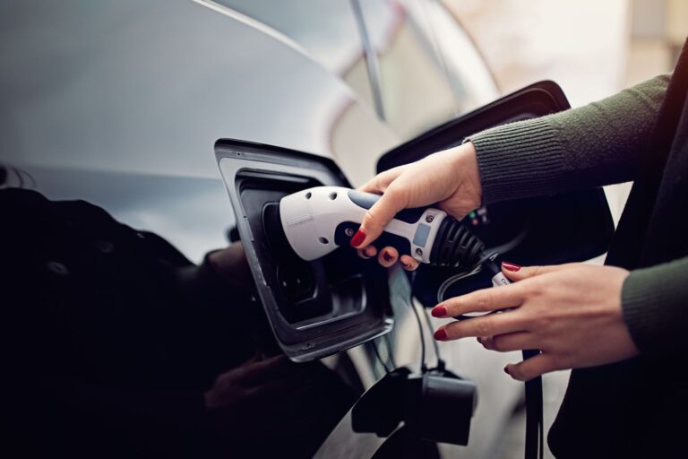 Woman plugging/unplugging EV charging cable